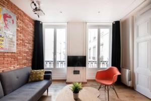 a living room with a couch and a tv at Cabana & Appartement type Loft - Bellecour in Lyon