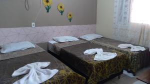 two beds with towels on them in a room at Casa Pedacinho do Céu in Estivado