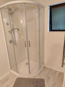 a shower with a glass door in a bathroom at Harbourside Haven in Ohope Beach