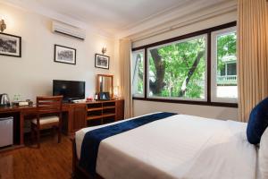 a bedroom with a bed and a desk and a window at Hanoi Golden Moon Hotel in Hanoi