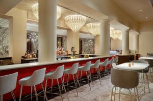 un bar avec une rangée de tabourets dans un restaurant dans l'établissement Le Méridien Tampa, The Courthouse, à Tampa