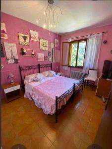 - une chambre avec un lit et un mur rose dans l'établissement Villa I Parioli, à Guiglia