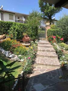 un jardin avec une passerelle en pierre en face d'une maison dans l'établissement Villa I Parioli, à Guiglia