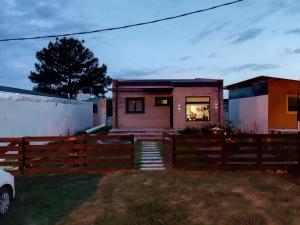 ein Haus mit einem Zaun davor in der Unterkunft Casa de los lagos in Rivera