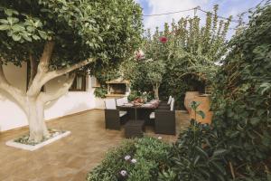 a garden with a table and chairs and trees at Villa Althaea in Loutra