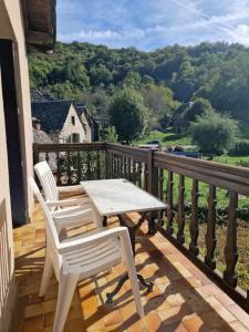 two white chairs and a table on a balcony at Maison Vidal II in Coubisou