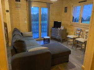 ein Wohnzimmer mit einem Sofa und einem TV in der Unterkunft Gîte Sous-Poupet 