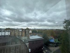 a view of a city with buildings and a cloudy sky at Nice 3 bedroom Bayswater in London