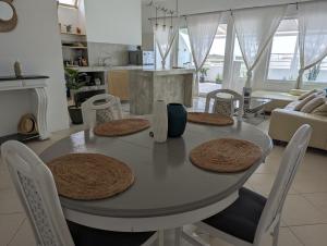 a dining room table with chairs and a kitchen at Tropical Leaves Sea view penthouse in Sal Rei