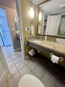 een badkamer met een wastafel, een toilet en een spiegel bij Caravelle Resort in Myrtle Beach