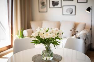 a vase of white flowers sitting on a table at Flatbook - City Center SPA Apartments Toruńska 11 in Gdańsk