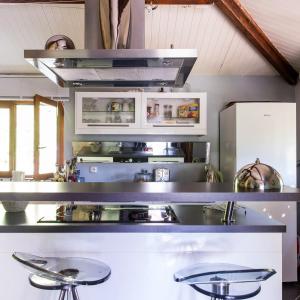 - une cuisine avec une cuisinière et des tabourets dans l'établissement Maison Eureka Chantilly Gouvieux, à Gouvieux
