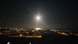 een uitzicht op een stad 's nachts met de maan bij Casa vacanza LMT in Aci Catena