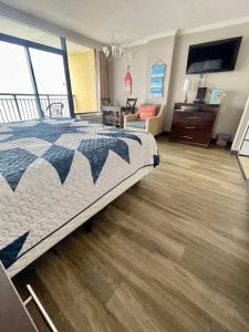Caravelle Resort في ميرتل بيتش: غرفة نوم بسرير كبير وأرضيات خشبية