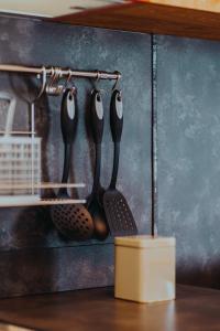 a wall with four utensils hanging on a rack at The Attico in Padenghe sul Garda