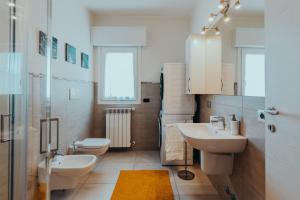 ein Badezimmer mit zwei Waschbecken und einem WC in der Unterkunft The Attico in Padenghe sul Garda
