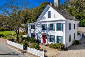 una casa blanca con una puerta roja en una calle en Cape Cod Mod en Provincetown