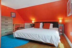 a bedroom with a bed with an orange wall at Cape Cod Mod in Provincetown