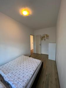 a bedroom with a bed and a light on the ceiling at Kristály Apartman in Szeged