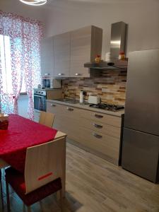 cocina con mesa roja y nevera en Cherry's house, en Celleno