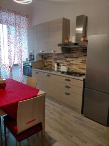 a kitchen with a red table and a refrigerator at Cherry's house in Celleno