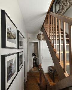 un escalier dans une maison avec des photos sur les murs dans l'établissement Maison Eureka Chantilly Gouvieux, à Gouvieux