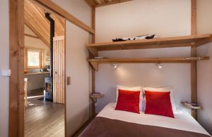 - une chambre avec des lits superposés et des oreillers rouges dans l'établissement Huttopia Bourg St Maurice, à Bourg-Saint-Maurice