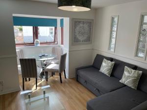 a living room with a couch and a table at Coastal Apartment 2 Bedrooms, Sleeps upto 6, Free Parking in Prestonpans