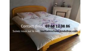 Andrésy的住宿－la villa des chats，一张床上有白色床单和粉红色的鲜花
