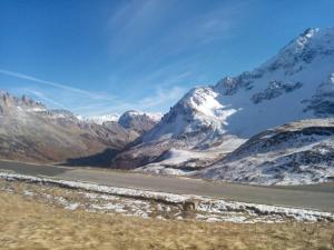 une chaîne de montagnes enneigée avec une route au premier plan dans l'établissement Agréable appartement au calme avec vue montagne, commune de Le Monêtier les Bains - Le Freyssinet, à Les Guibertes
