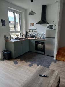 a kitchen with green cabinets and a refrigerator at Chez Sindy et Olivier in Crèvecoeur-le-Grand