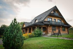 a large wooden house with a black roof at Sokolisko - pensjonat agroturystyczny in Wysoczany