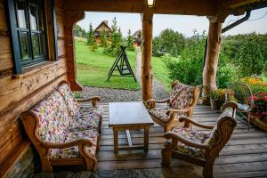 a porch with two chairs and a table on a house at Sokolisko - pensjonat agroturystyczny in Wysoczany +41 photos