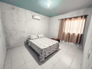 1 dormitorio con cama y ventana. en Casa em Aurora do Tocantins, en Manhã