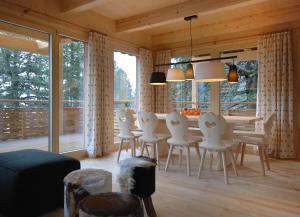 a living room with a table and white chairs at AlpenChalet ZirbenDuft in Turracher Hohe