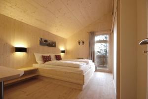- une chambre avec un lit dans une pièce dotée d'une fenêtre dans l'établissement AlpenChalet ZirbenDuft, à Turracher Höhe