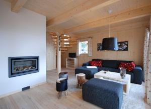 a living room with a couch and a fireplace at AlpenChalet ZirbenDuft in Turracher Hohe