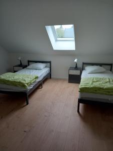 1 Schlafzimmer mit 2 Betten und einem Dachfenster in der Unterkunft Chez Sindy et Olivier in Crèvecoeur-le-Grand