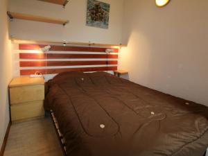 a bedroom with a bed and a wooden headboard at Appartement Saint-François-Longchamp, 2 pièces, 6 personnes - FR-1-635-39 in Saint-François-Longchamp