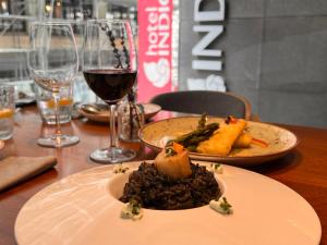 a table with two plates of food and a glass of wine at Hotel Indigo Madrid - Gran Vía by IHG in Madrid