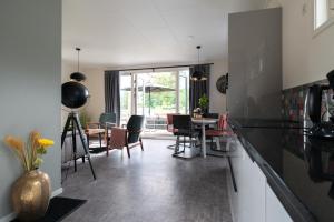 een keuken en eetkamer met een tafel en stoelen bij Recreatiepark Maas en Bos in Wellerlooi