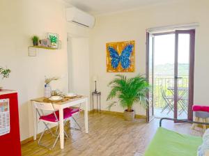 una habitación con una mesa y una pintura de mariposa en la pared en New apartment Beautiful Mountain view, en Collecorvino
