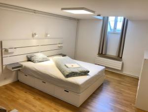 a white bedroom with a bed with a large headboard at Old Town Apartments in Bern