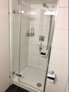 La salle de bains est pourvue d'une douche avec une porte en verre. dans l'établissement Old Town Apartments, à Berne