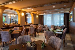 a restaurant with tables and chairs in a room at Grami Hotel in Bansko