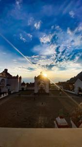 un bâtiment avec un coucher de soleil dans le ciel dans l'établissement Posada Mia Copacabana, à Copacabana