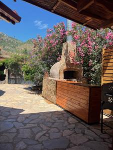 a outdoor pizza oven in a patio with flowers at Lb Boutique Hotel in Kumluca
