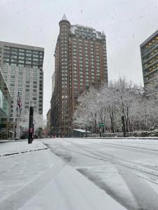 uma rua coberta de neve numa cidade com edifícios altos em InterContinental Montreal, an IHG Hotel em Montréal