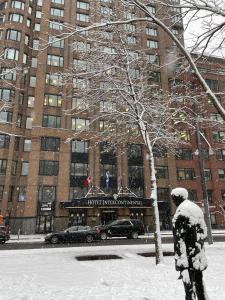 une personne debout dans la neige devant un bâtiment dans l'établissement InterContinental Montreal, an IHG Hotel, à Montréal