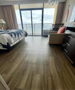 a bedroom with a bed and a view of a balcony at Caravelle Resort in Myrtle Beach